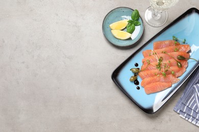 Photo of Delicious salmon carpaccio served on light grey table, flat lay. Space for text