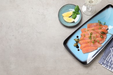 Delicious salmon carpaccio served on light grey table, flat lay. Space for text