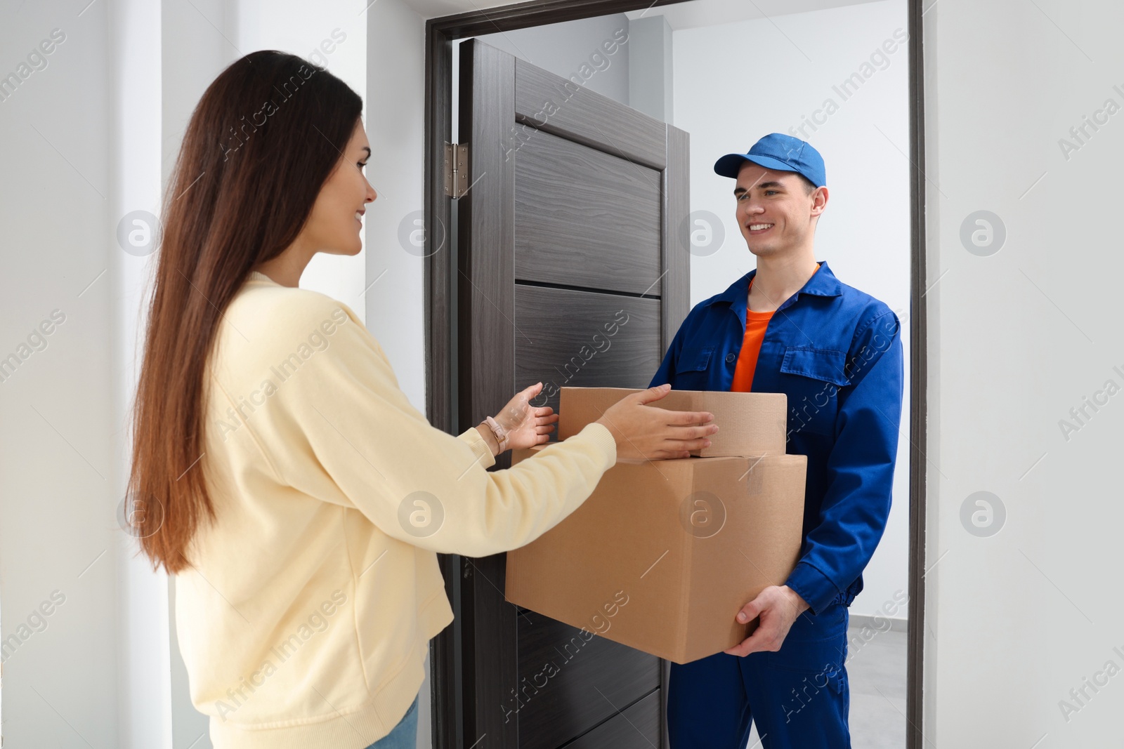 Photo of Courier giving parcels to woman at home