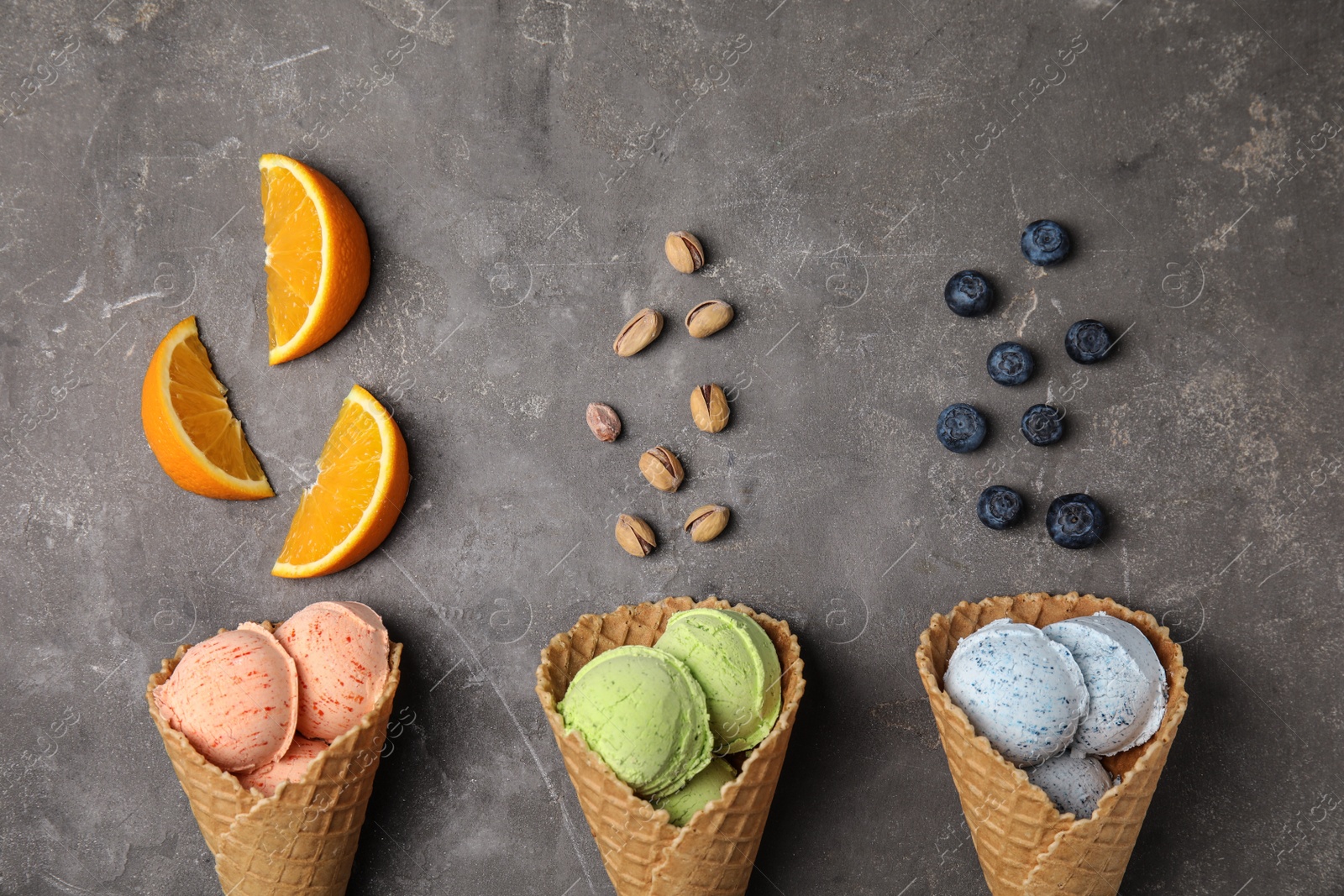 Photo of Flat lay composition with delicious ice creams in waffle cones on table