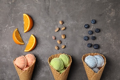 Flat lay composition with delicious ice creams in waffle cones on table