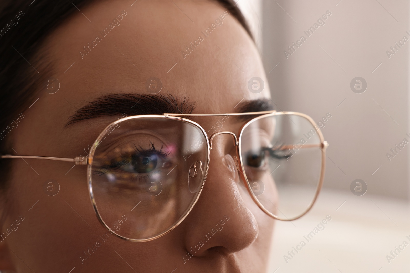 Photo of Woman wearing glasses on blurred background, closeup