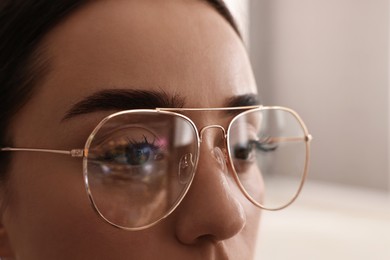 Woman wearing glasses on blurred background, closeup