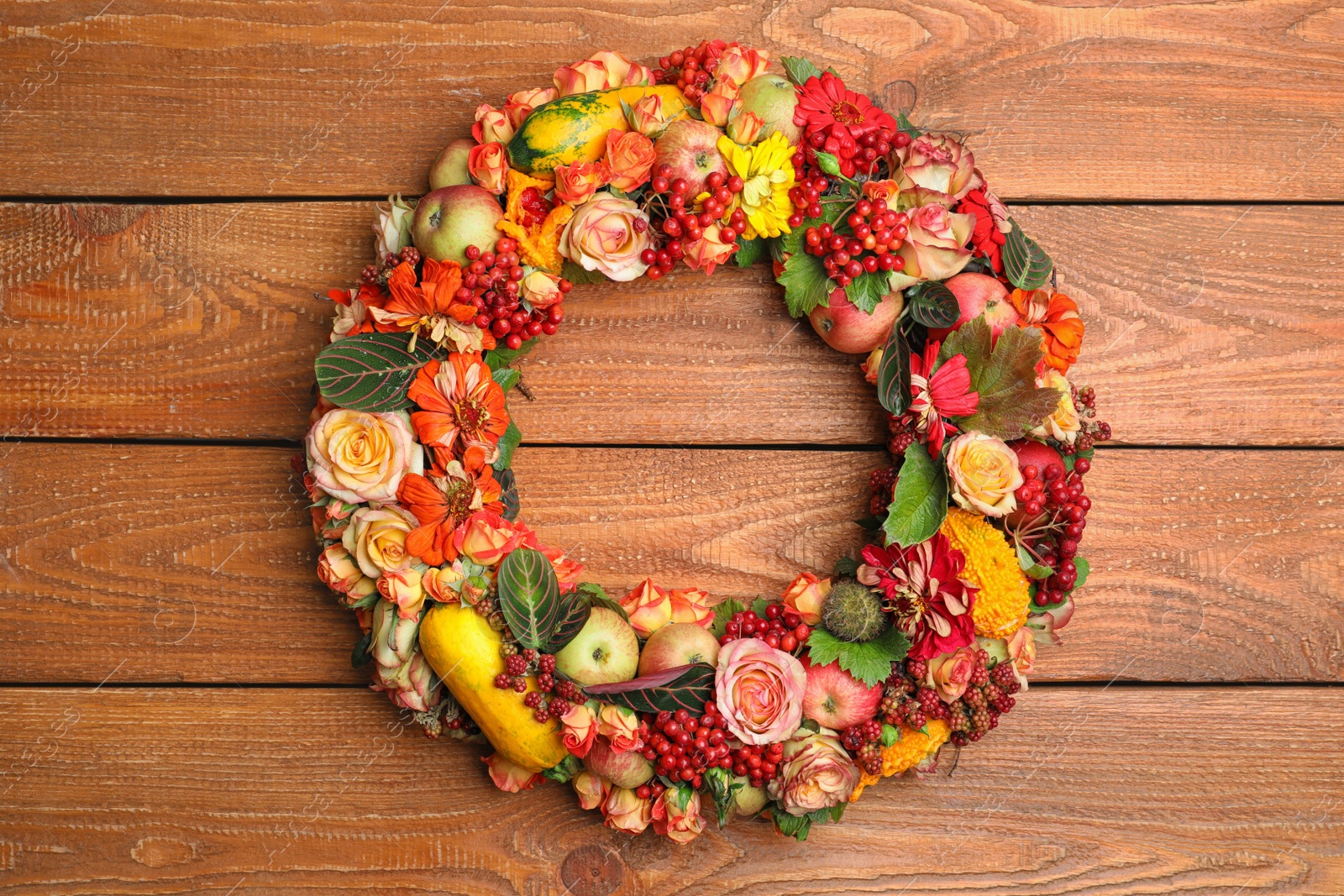 Photo of Beautiful autumnal wreath with flowers, berries and fruits on wooden background, top view. Space for text