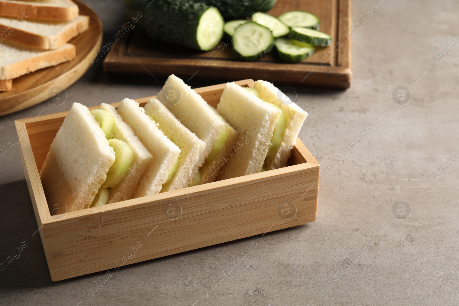 Photo of Tasty sandwiches with cucumber on grey table