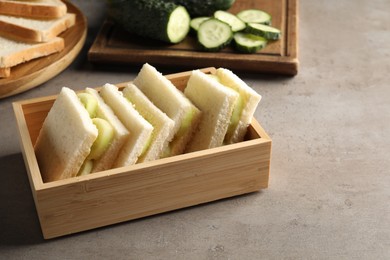 Photo of Tasty sandwiches with cucumber on grey table