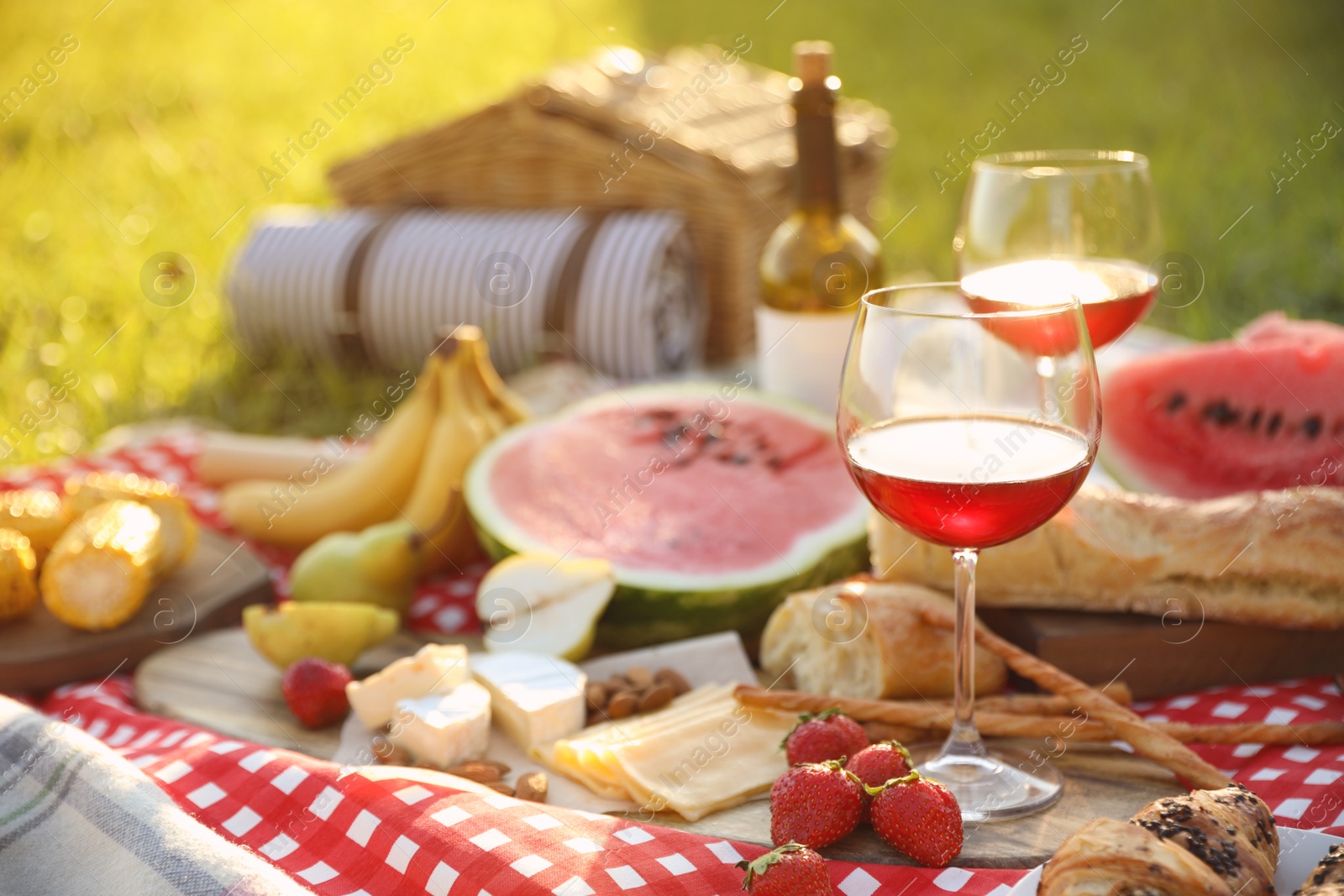 Photo of Picnic blanket with delicious food and drinks outdoors on sunny day