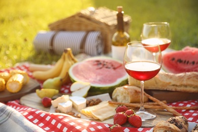 Picnic blanket with delicious food and drinks outdoors on sunny day