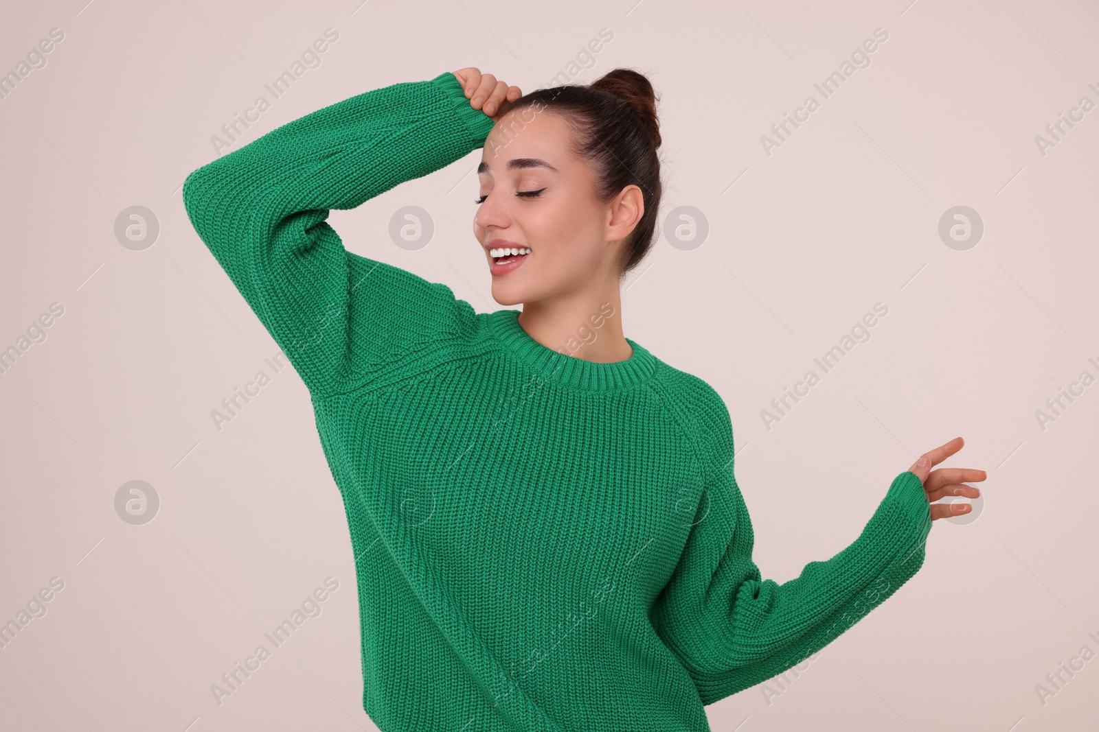Photo of Beautiful young woman in stylish warm sweater on light grey background