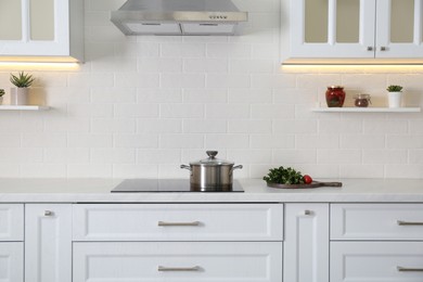 Elegant kitchen interior with modern stove and stylish furniture