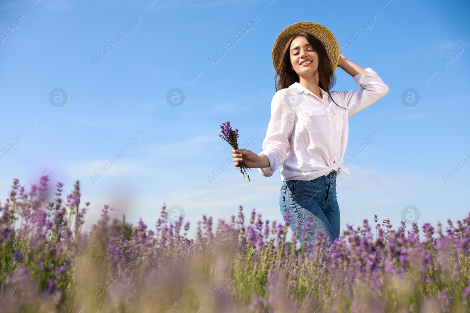 Photo of Young woman with lavender bouquet in field on summer day