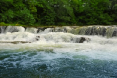 Photo of Blurred view of river with rapids near forest