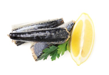 Canned mackerel fillets with parsley and lemon on white background, top view