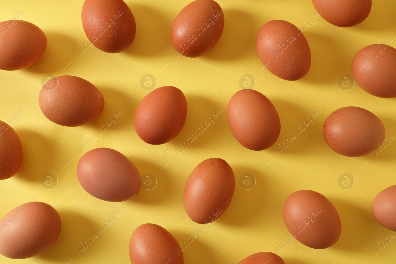 Photo of Fresh chicken eggs on yellow background, flat lay