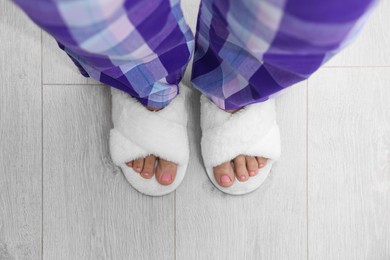 Photo of Woman wearing white soft slippers, top view