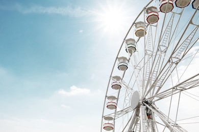 Photo of Large white observation wheel against sky, space for text