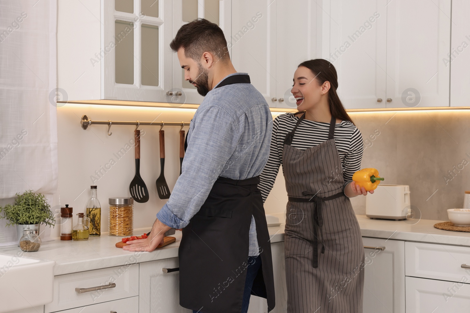 Photo of Happy lovely couple cooking together in kitchen