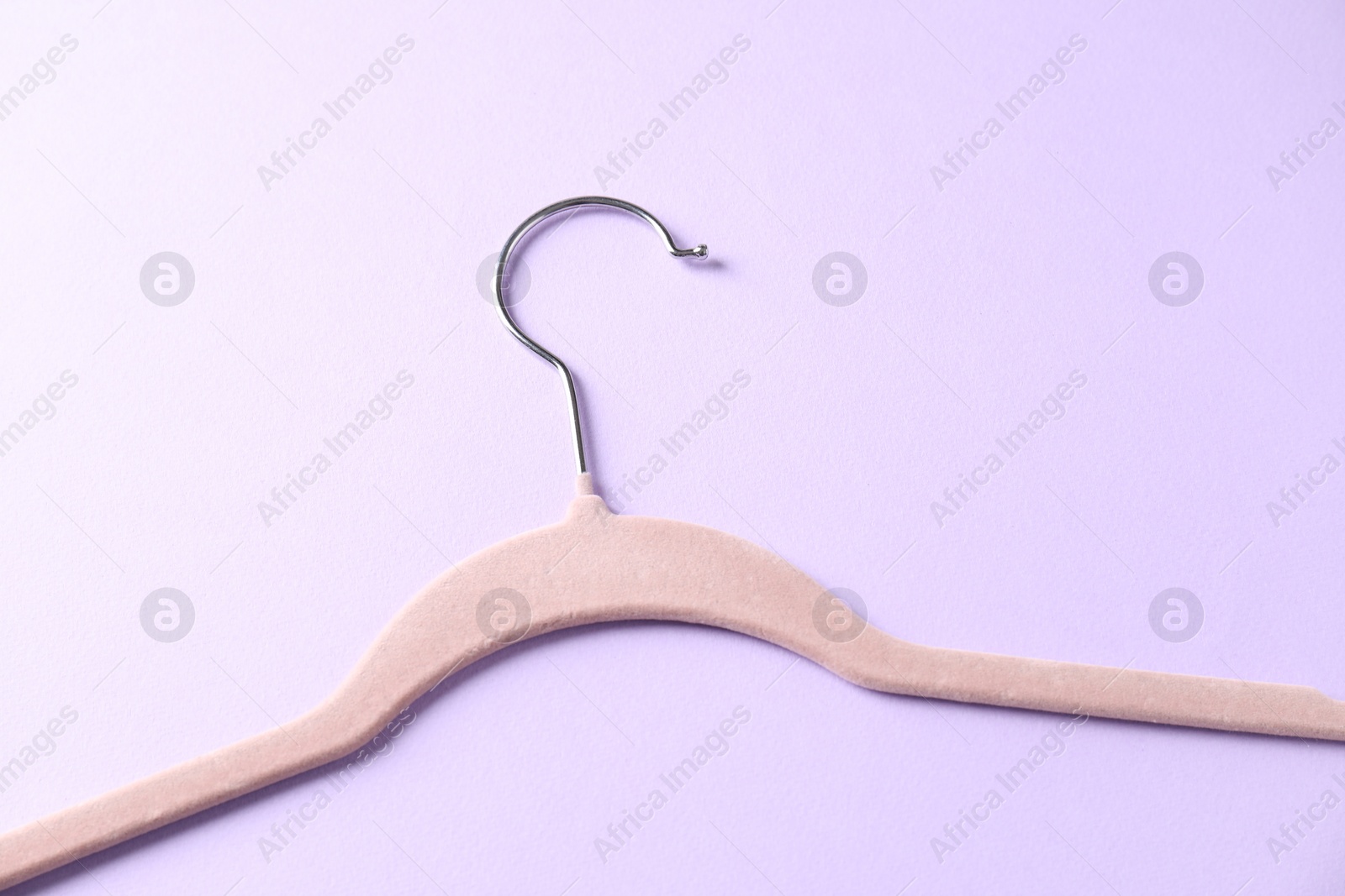 Photo of One beige hanger on violet background, top view