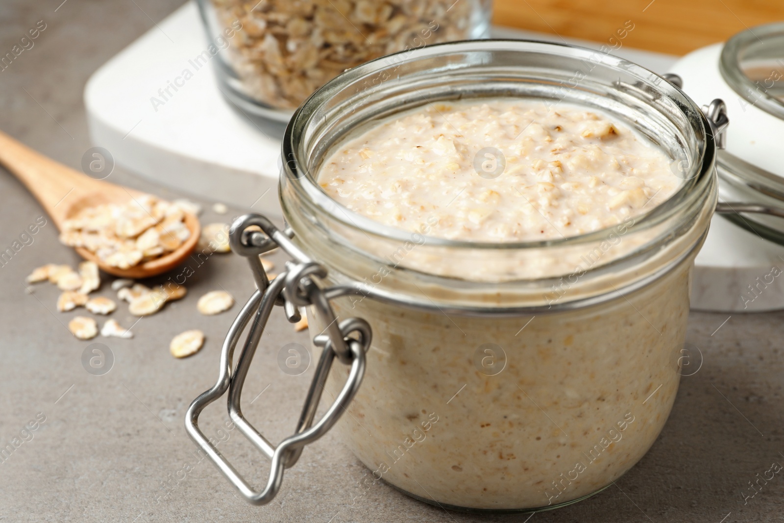 Photo of Handmade face mask and oatmeal on grey table