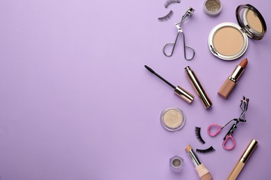 Photo of Eyelash curlers and makeup products on violet background, flat lay. Space for text