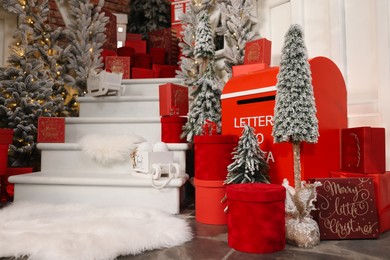 Photo of Christmas tree, gift boxes and festive decor indoors. Interior design