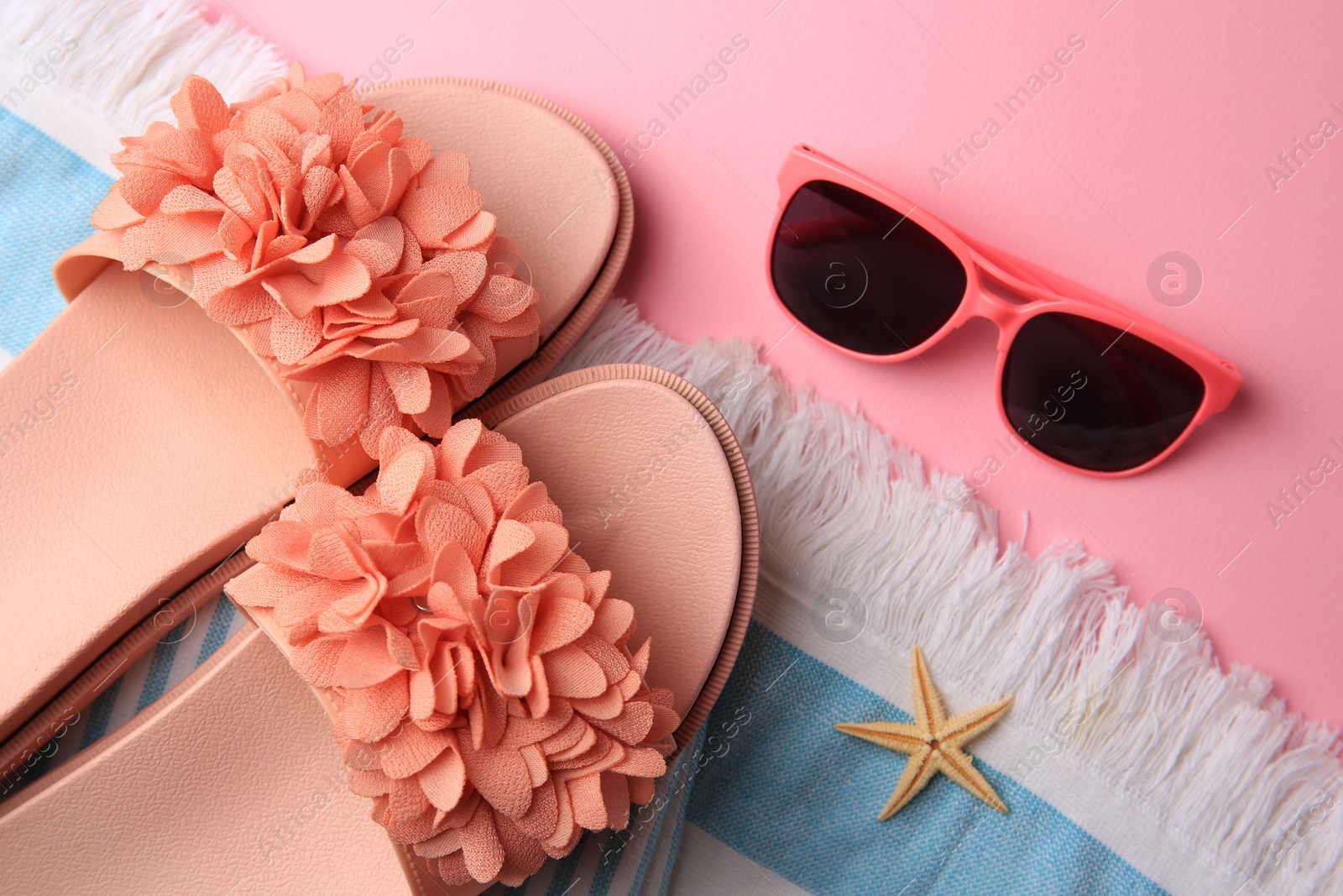 Photo of Flat lay composition with beach accessories on pink background