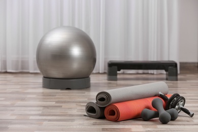 Photo of Set of fitness equipment on floor indoors. Space for text