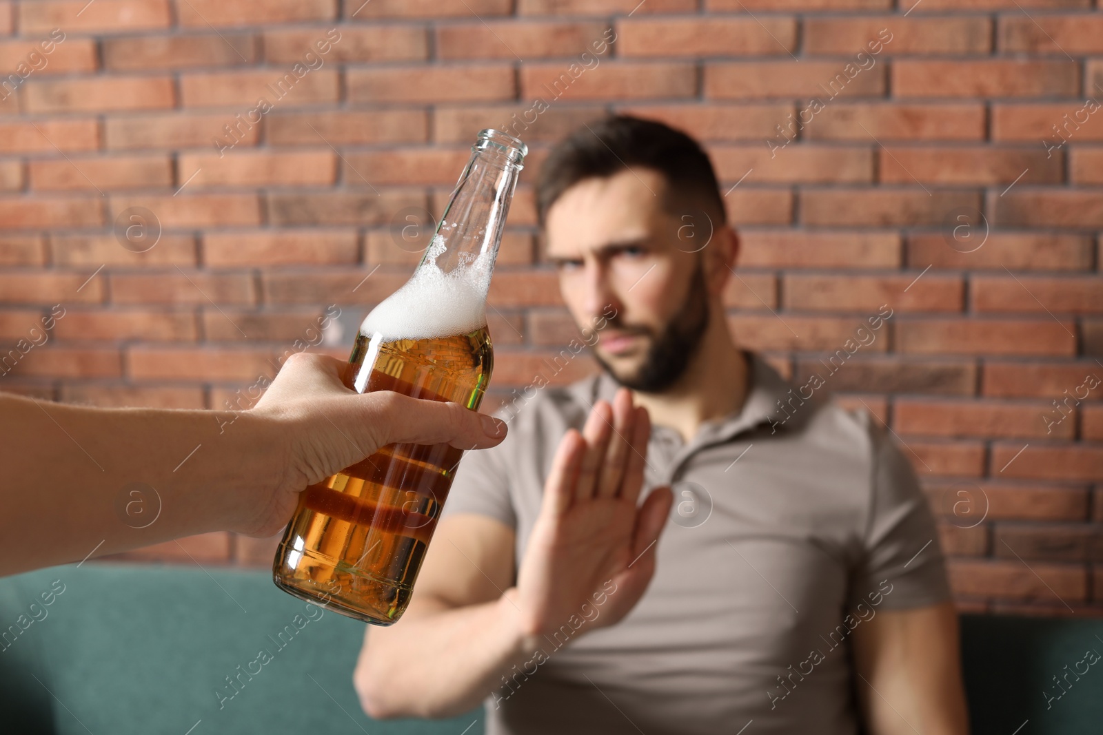 Photo of Man refusing to drink beer indoors, closeup. Alcohol addiction treatment