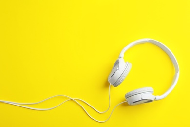 Photo of Stylish headphones on color background, top view. Space for text