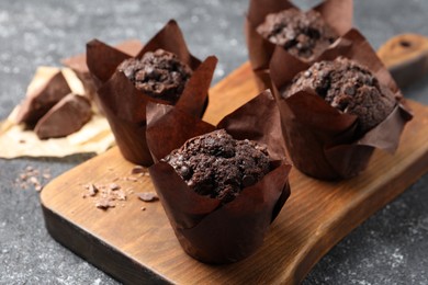 Tasty chocolate muffins on grey table, closeup