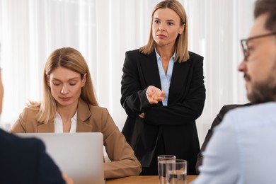 Businesswoman having meeting with her employees in office