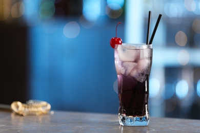 Photo of Fresh alcoholic cocktail with cherry on bar counter, space for text