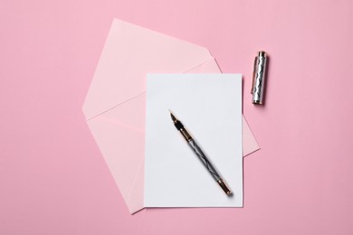 Photo of Blank sheet of paper, letter envelope and pen on pink background, top view
