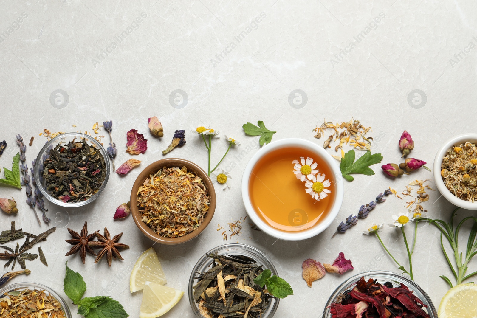 Photo of Flat lay composition with fresh brewed tea and dry leaves on light table, space for text