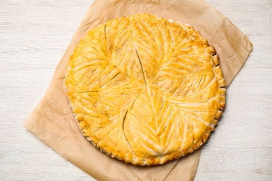 Photo of Traditional galette des rois on white wooden table, top view