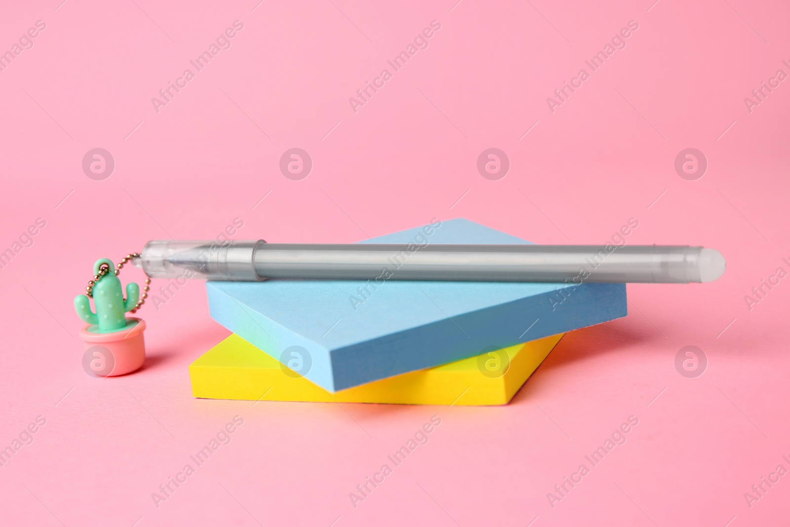 Photo of Colorful paper notes with erasable pen on pink background, closeup