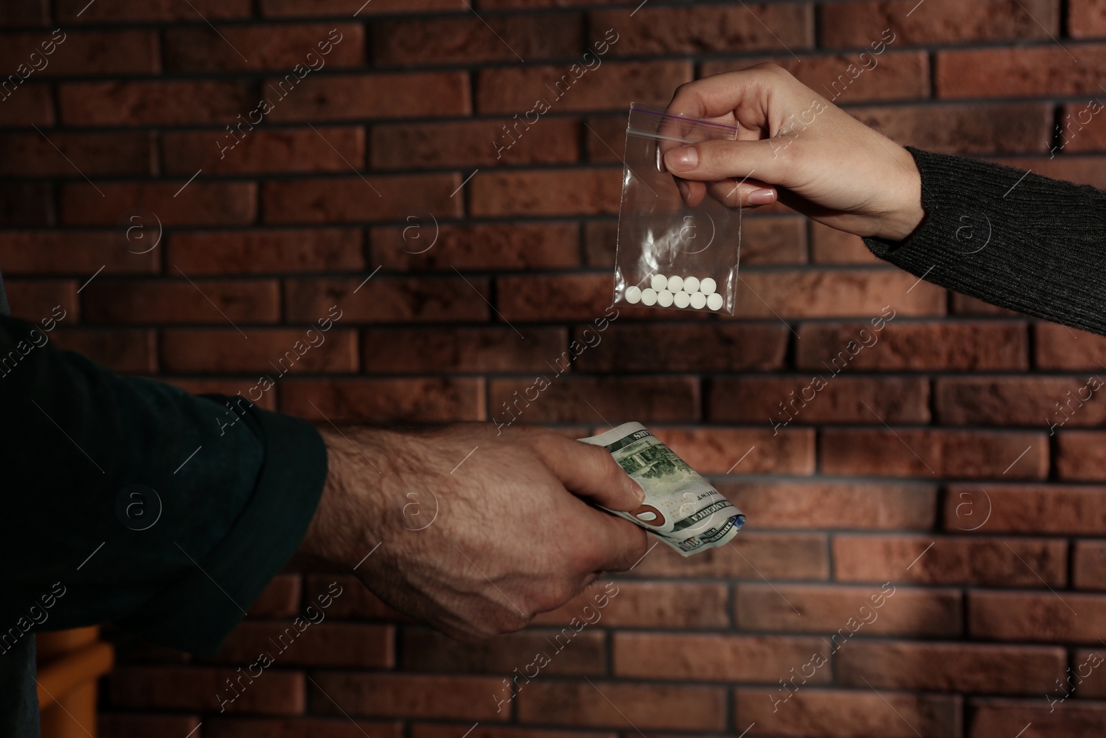 Photo of Man buying drugs from dealer near brick wall, closeup of hands