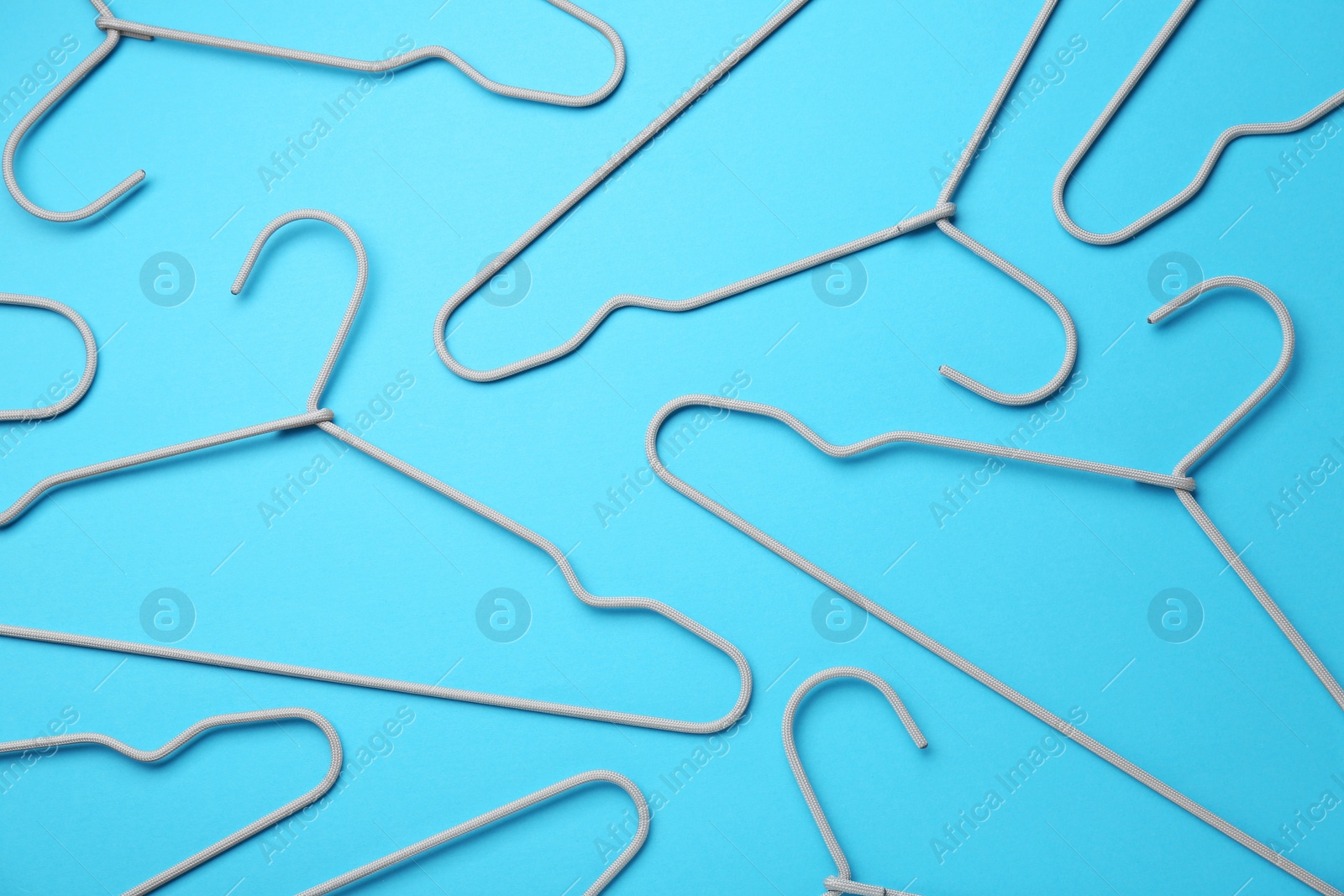 Photo of Hangers on light blue background, flat lay