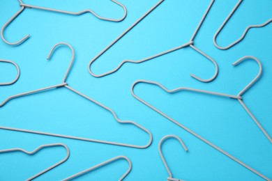 Hangers on light blue background, flat lay