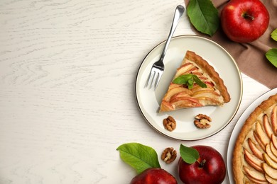 Delicious apple pie, leaves and fruits on white wooden table, flat lay. Space for text