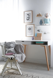 Stylish child's room interior with desk and beautiful pictures