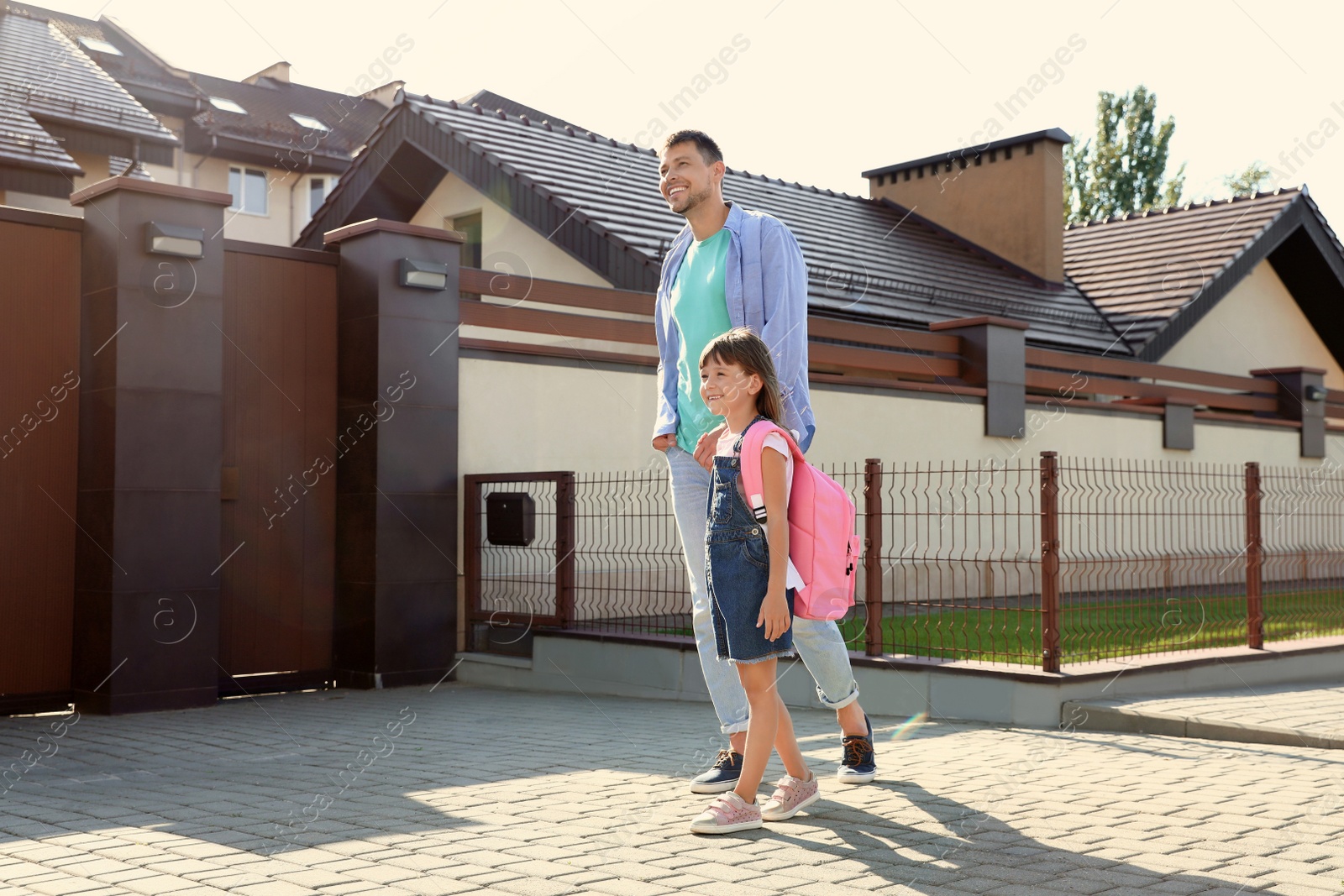 Photo of Happy father taking his little child to school on street