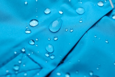 Photo of Light blue waterproof fabric with water drops as background, closeup