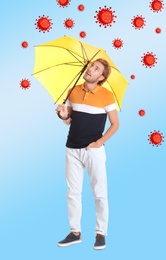 Image of Man protecting himself from viruses with yellow umbrella as symbol of strong immunity