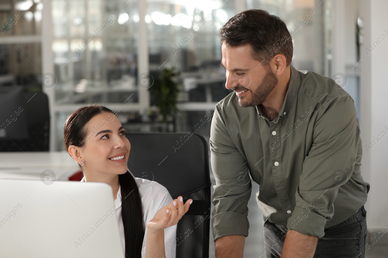 Photo of Colleagues near computer at workplace in office