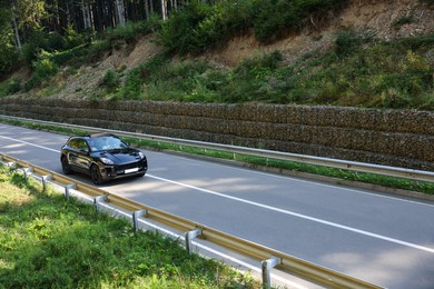 Photo of Picturesque view of asphalt road with modern black car outdoors