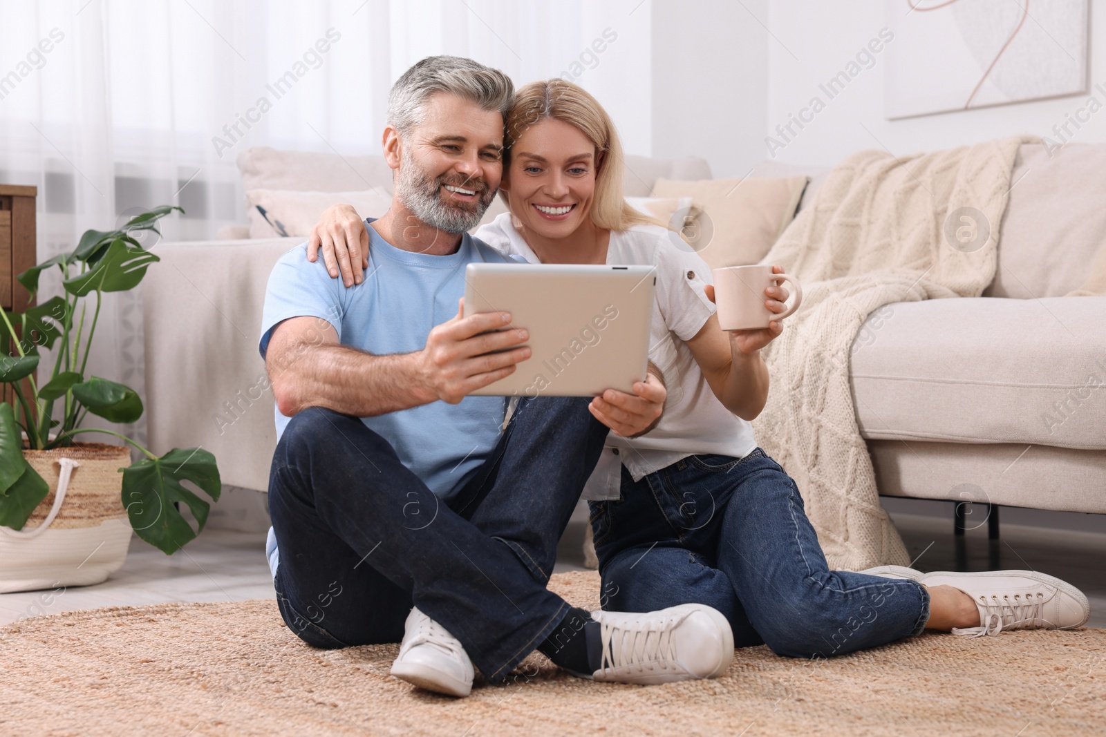 Photo of Happy affectionate couple with tablet at home. Romantic date