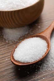 Granulated sugar on wooden table, closeup view