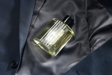 Photo of Luxury men's perfume in bottle on grey jacket, above view