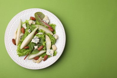 Photo of Delicious pear salad on green background, top view. Space for text